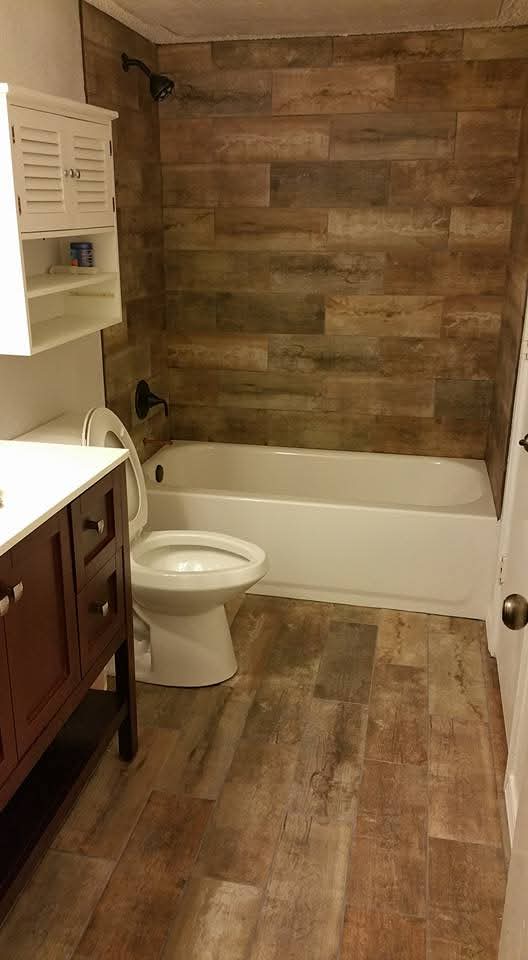 Completed bathroom with tile, vanity, and tub surround