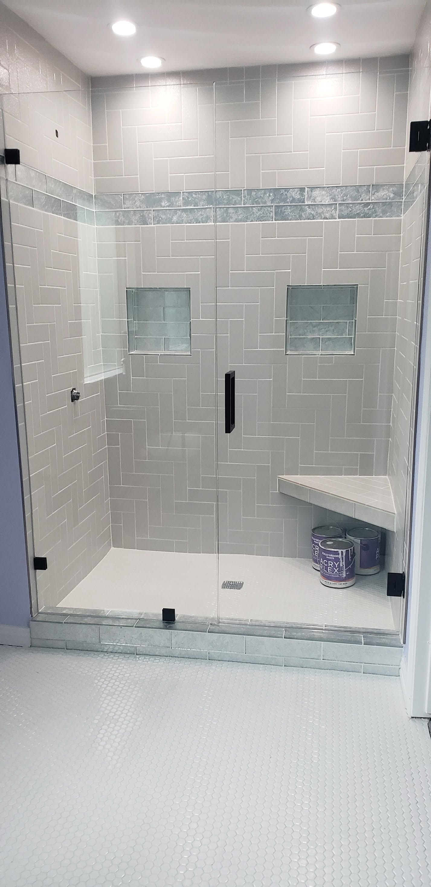 Completed walk-in shower with glass enclosure and two niches