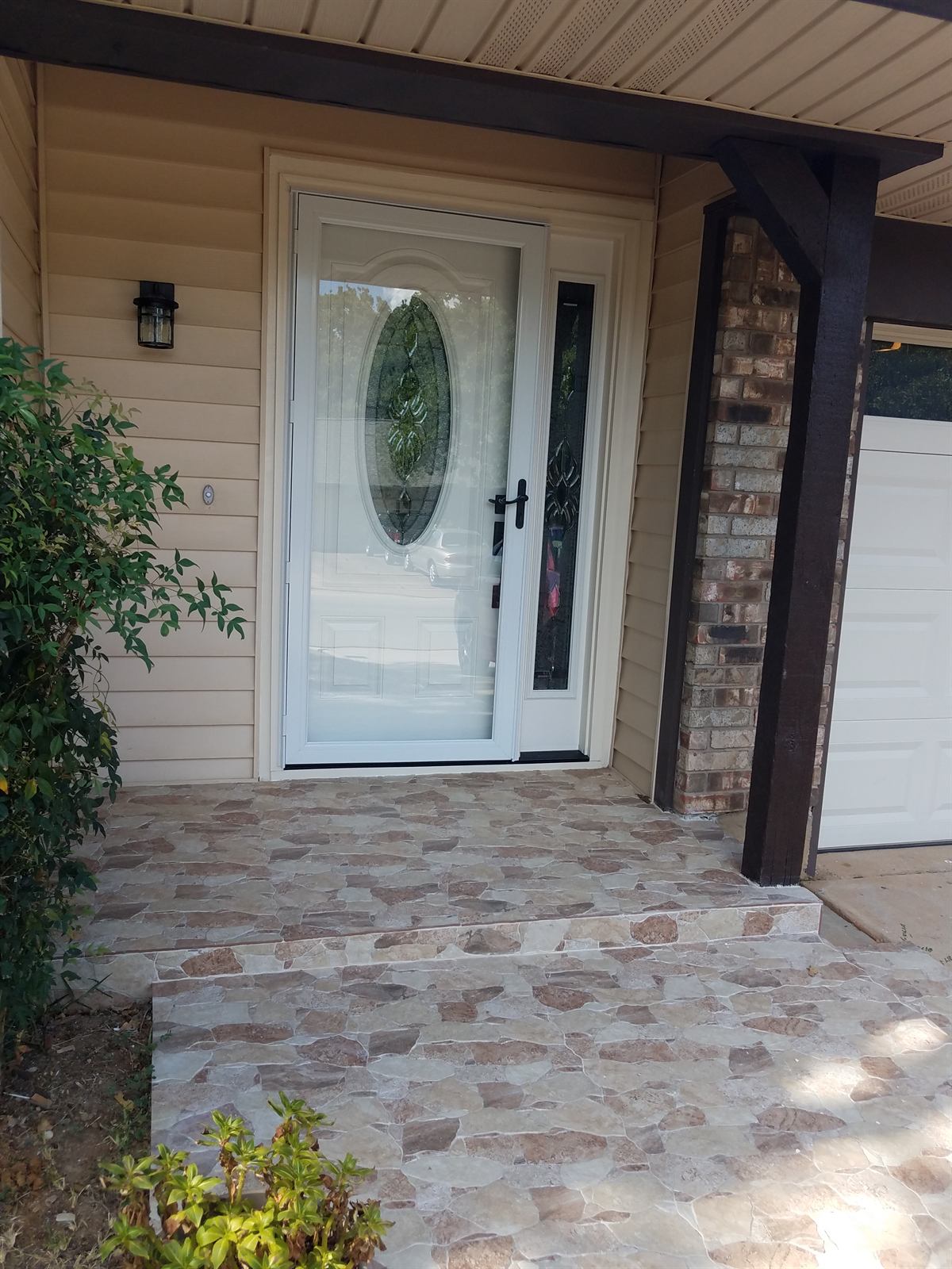 Completed stone tile entry porch beside the front door