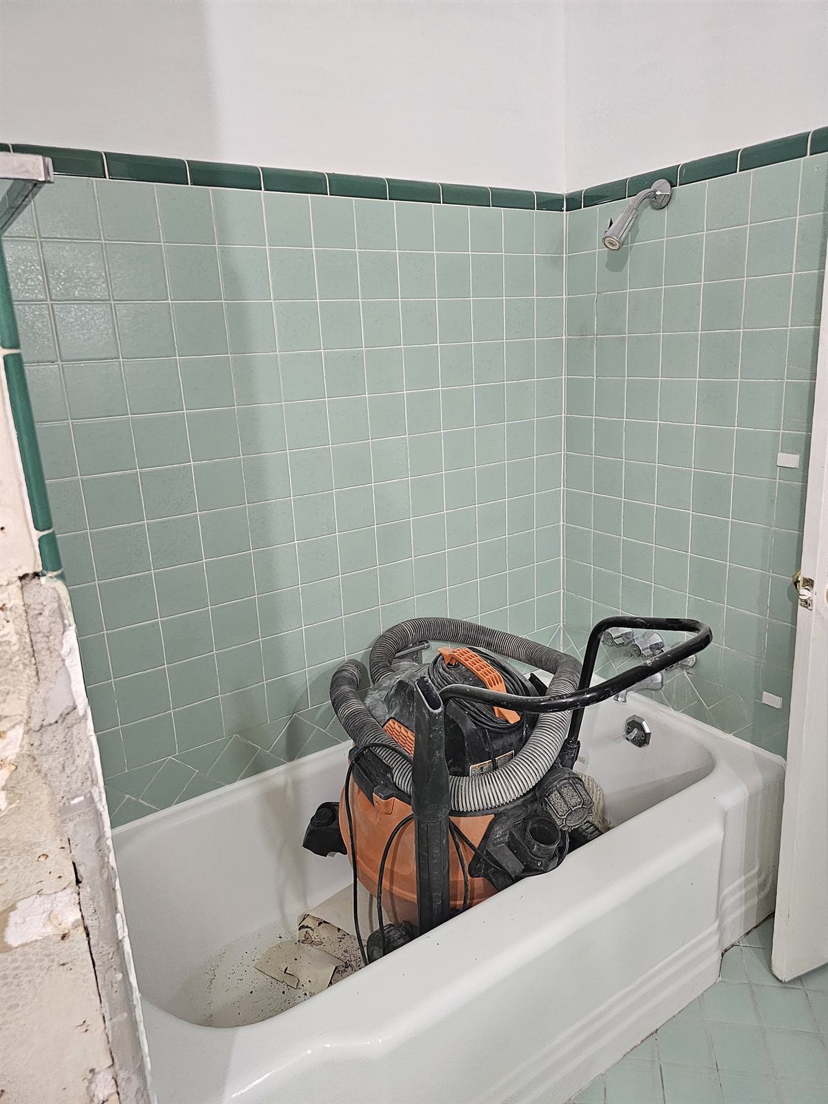 Original bathroom with green wall tile and an alcove tub